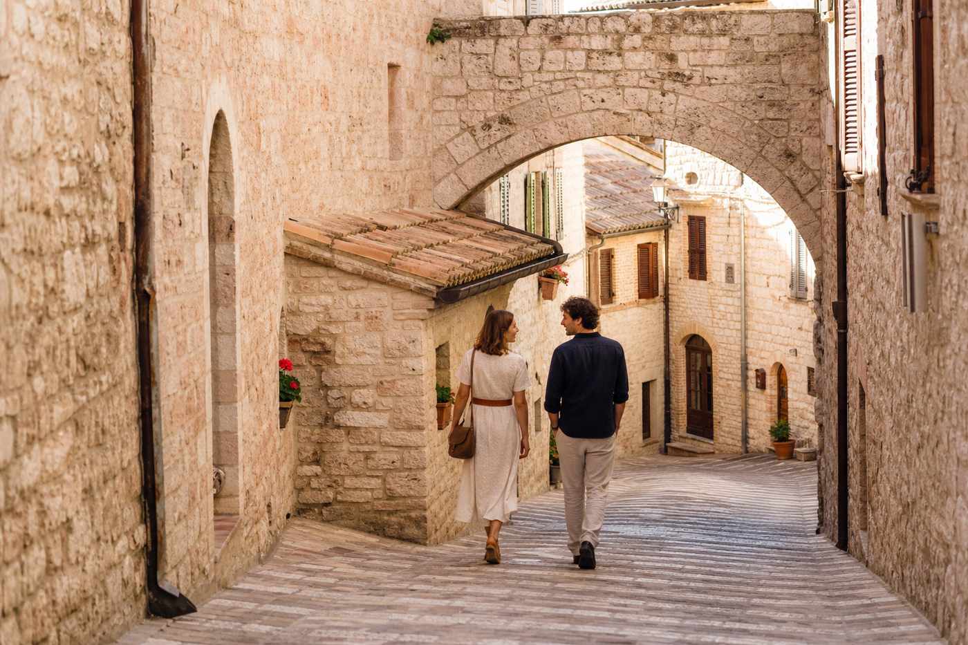 Coppia a passeggio in un borgo umbro prima di una proposta di matrimonio
